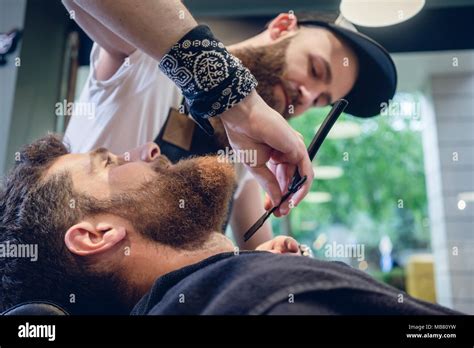 Bearded Young Man Ready For Shaving In The Hair Salon Of A Skilled