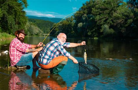 Catching Fish Two Men Friends Fisherman Fishing On River Stock Image