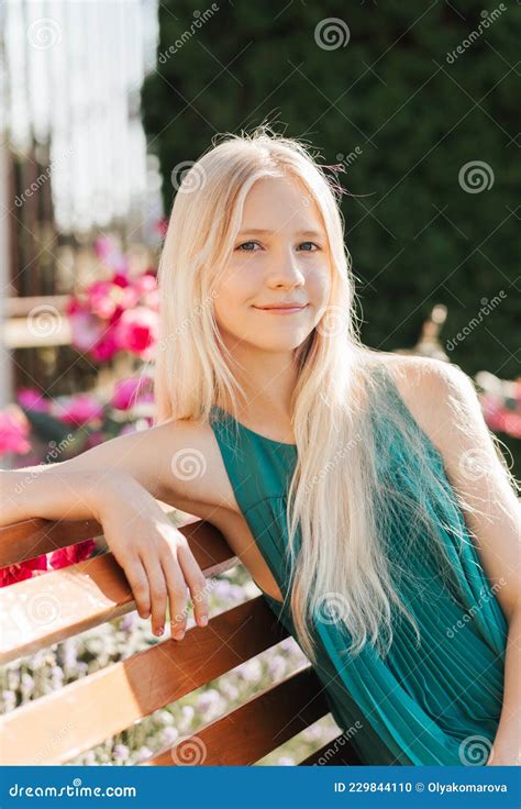 Une Belle Adolescente Aux Longs Cheveux Blonds Est Assise Sur Un Banc