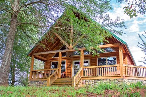 a log cabin nestled in the woods with stairs leading up to it's second ...