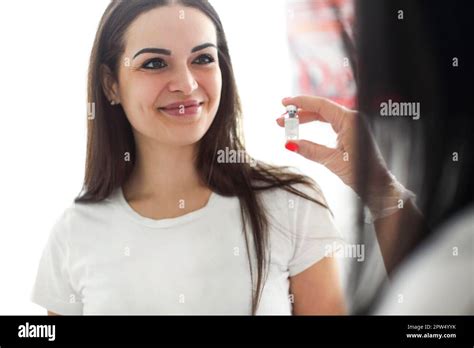 Professional Female Beautician Showing Filler In Glass Bottle For Woman Before Injection In