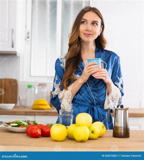 Attractive Woman Wearing in Housecoat Making Coffee at Kitchen Stock