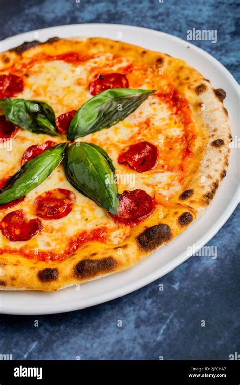 Fresh Tasty Pepperoni Pizza With Basil Leaves On The Table Stock Photo