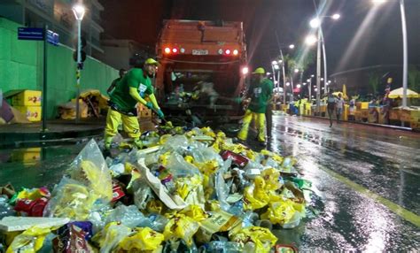 ALTAS HORAS Debaixo de chuva garis recolhem lixo deixado por foliões