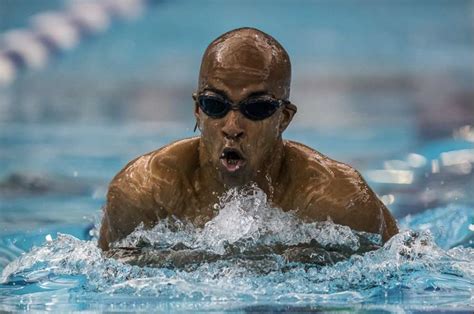 A Man Swimming In A Pool With Goggles On