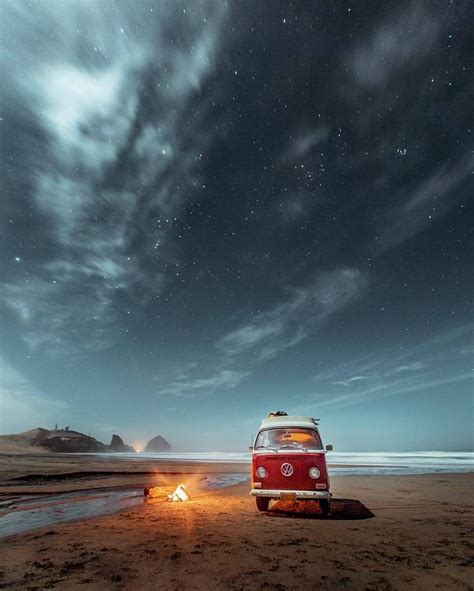 An Old Vw Bus Is Parked On The Beach At Night With Stars In The Sky