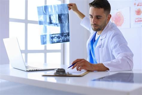 El doctor guapo está hablando con una paciente joven y haciendo Foto