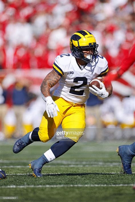 A Football Player Running With The Ball In His Hand During A Game