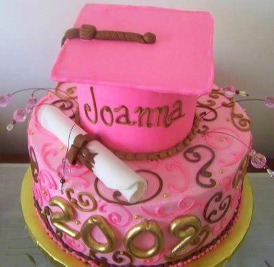 A Pink Graduation Cake With A Mortar And Diploma On Top Sitting On A Table