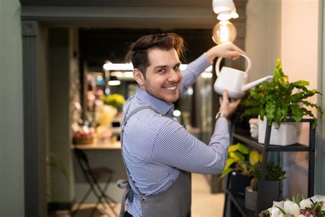 Premium Photo Male Florist Watering Potted Plants From A Watering Can