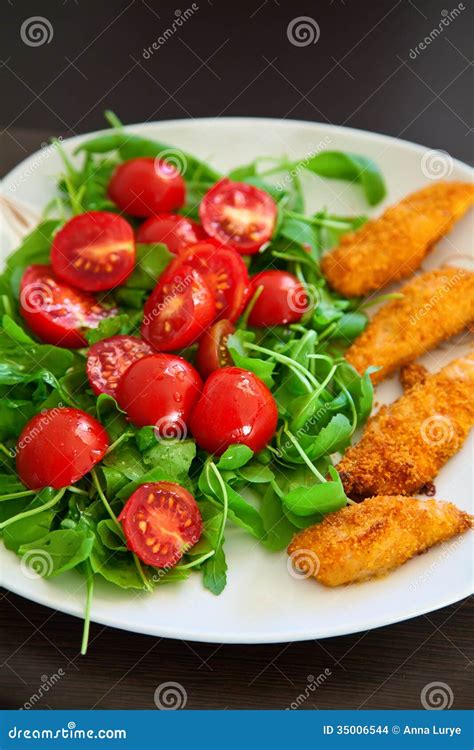 Chicken Nuggets Served With Ruccola And Cherry Tomato Stock Photo