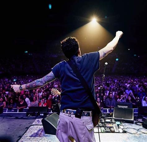 A Man Standing On Top Of A Stage With His Arms Outstretched In Front Of