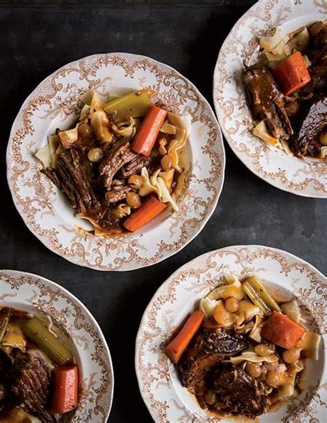 Four Plates Filled With Meat And Vegetables On Top Of A Black