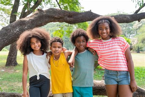 Retrato de niños afroamericanos felices de pie y abrazándose juntos en