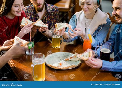 Multiracial Happy Young People Eating Pizza In Pizzeria Cheerful