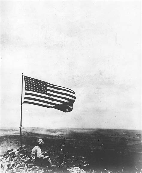 Photo An American Marine Sat Beneath The American Flag Atop Mount