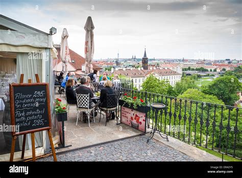 Tourists on the outdoor terrace of a restaurant below the castle ...