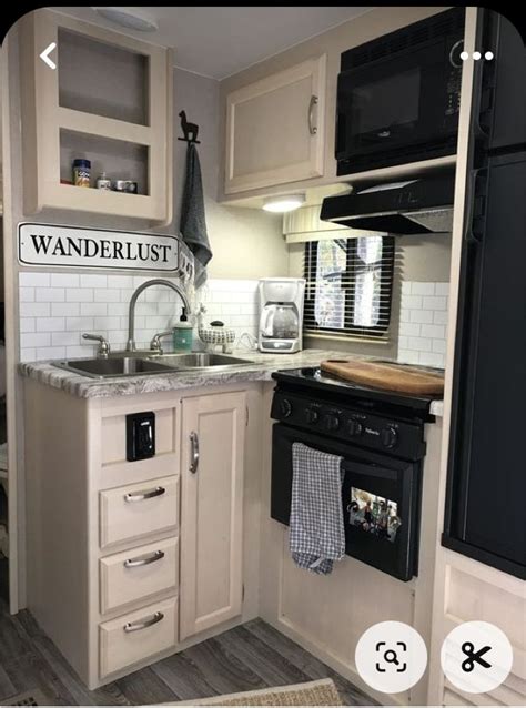 Compact Kitchen With White Cabinets And Black Appliances