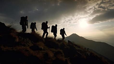 Un grupo de personas camina sobre una montaña con el sol brillando