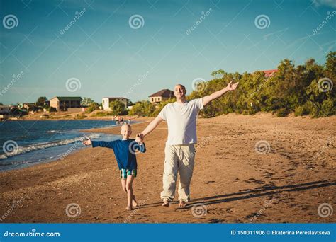 Padre Feliz E Hijo Que Caminan En La Playa Foto De Archivo Imagen De