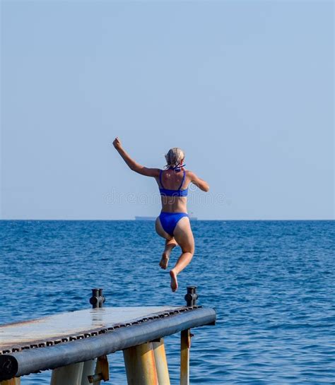 Una Bella Ragazza In Un Bikini Blu Ed In Un Cappello Bianco Sta