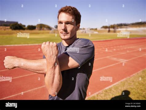 Hes Ready To Race A Handsome Young Runner Stretching On The Track