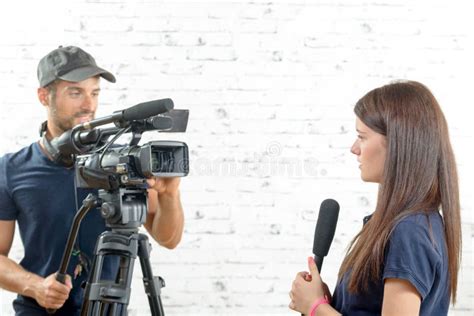 Journaliste De Jeune Femme Avec Un Microphone Et Un Cameraman Photo