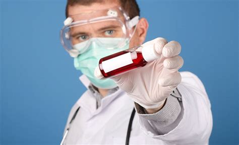 Scientist Holding Blood Sample In Test Tube With Globe In The