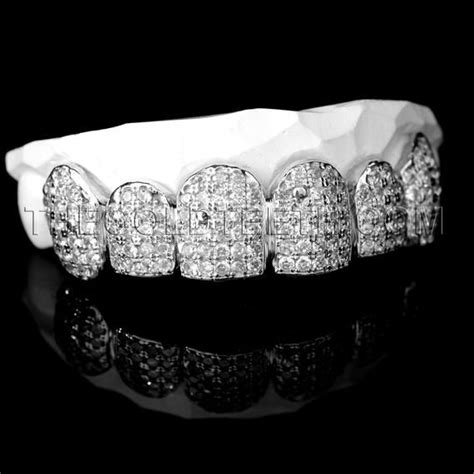 a white gold grill with diamonds on the top and bottom, in front of a ...