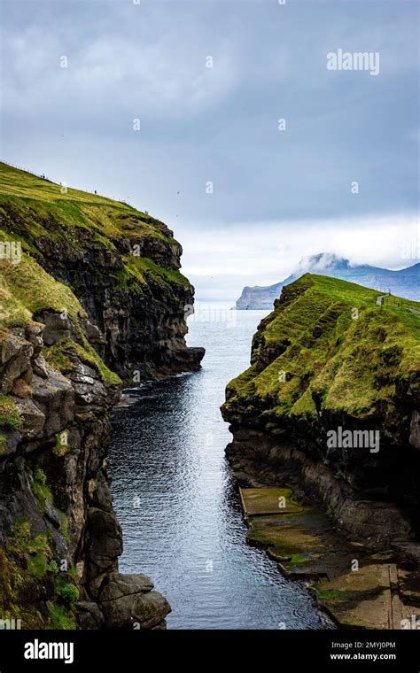 The Narrow Slot Canyon Harbor Of Gjogv Sandwiched Between Two Cliffs On