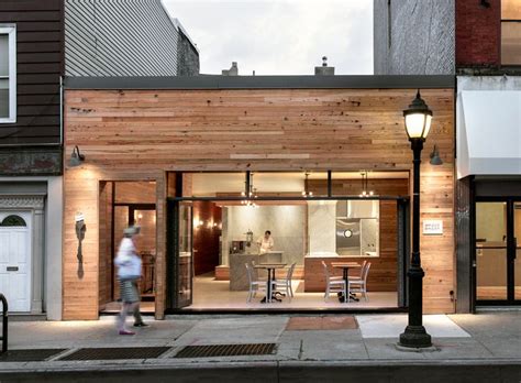 A Person Walking Down The Street In Front Of A Building With Wooden