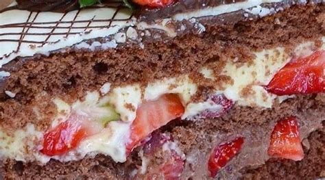 A Piece Of Chocolate Cake With Strawberries And Cream Frosting On The