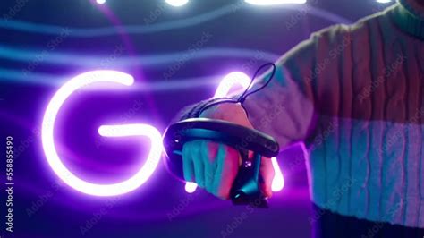 Cyber gamer in VR glasses plays virtual reality game in neon futuristic ...