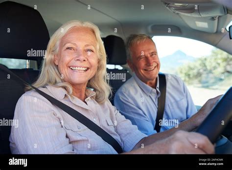 Senior White Woman And Her Husband Driving In Their Car Smiling To