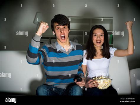 couple watching TV on the couch Stock Photo - Alamy