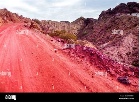 The red road through the island of Hormuz of volcanic origin. Terra ...