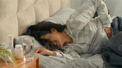 Woman lying on bed touch stomach pain menstrual period girl female