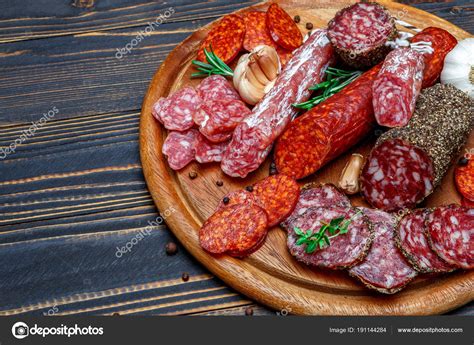 Various Types Of Dried Organic Salami Sausage On Wooden Cutting Board