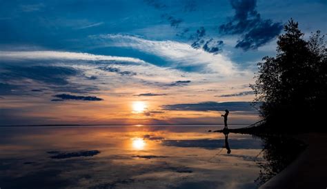 Premium Photo | Woman fishing on fishing rod spinning at sunset background