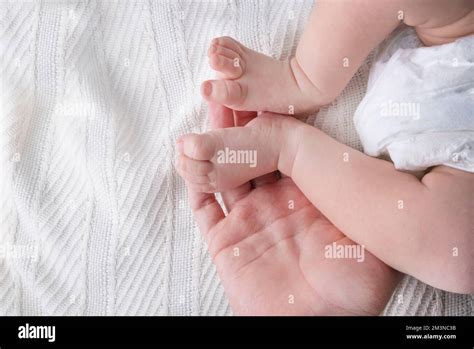 Female Hands Hold The Baby S Legs On A Light Or White Background Close