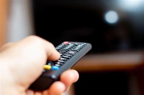 Premium Photo Male Hand Holding A Tv Remote And Trying To Turn On The Tv