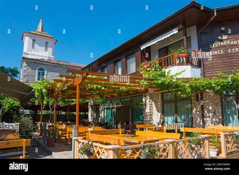 Cosy Outdoor Terrace Of A Restaurant With Wooden Tables Under A Clear