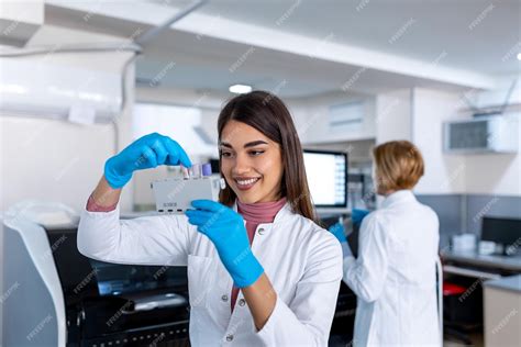 Asistente De Laboratorio Poniendo Tubos De Ensayo En El Soporte Médico