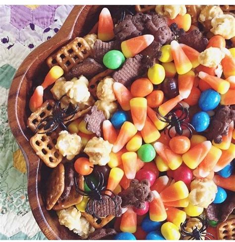 A Wooden Bowl Filled With Halloween Treats On Top Of A Table