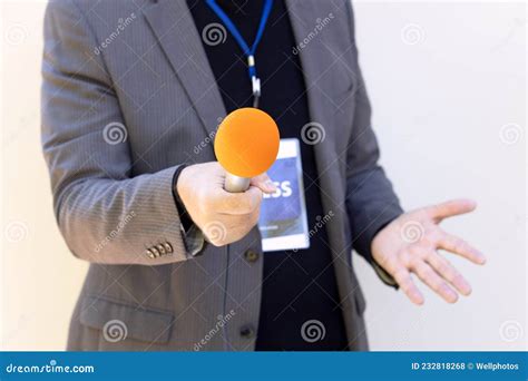 Periodista Con Gestos De Micrófono Durante Entrevista Con Medios Foto