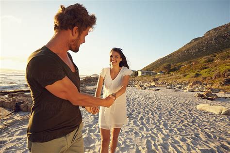 Cheerful Young Couple Walking Along Beach By Stocksy Contributor Jacob Lund Stocksy