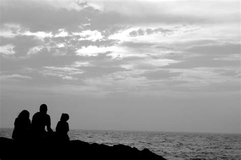 Silueta De Personas Sentadas En La Playa Contra El Cielo Foto Premium