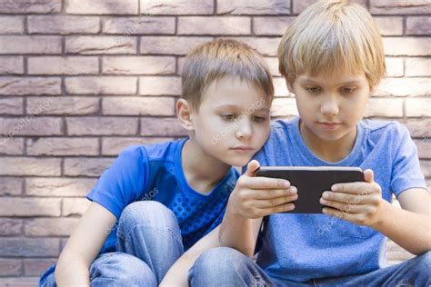 Bambini Con Cellulare Due Ragazzi Che Guardano Lo Schermo Giocano O