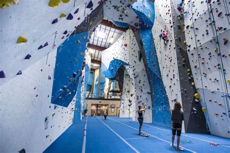 two people are climbing up the side of a rock wall in an indoor ...