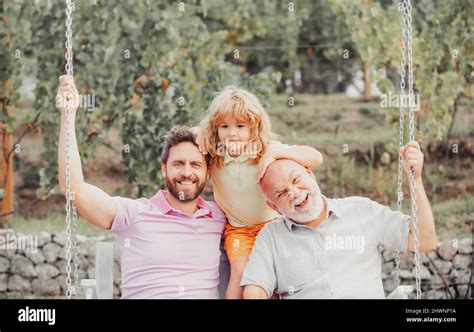 Garçon Fils Avec Père Et Grand Père Balançant Ensemble Dans Le Parc à Lextérieurtrois